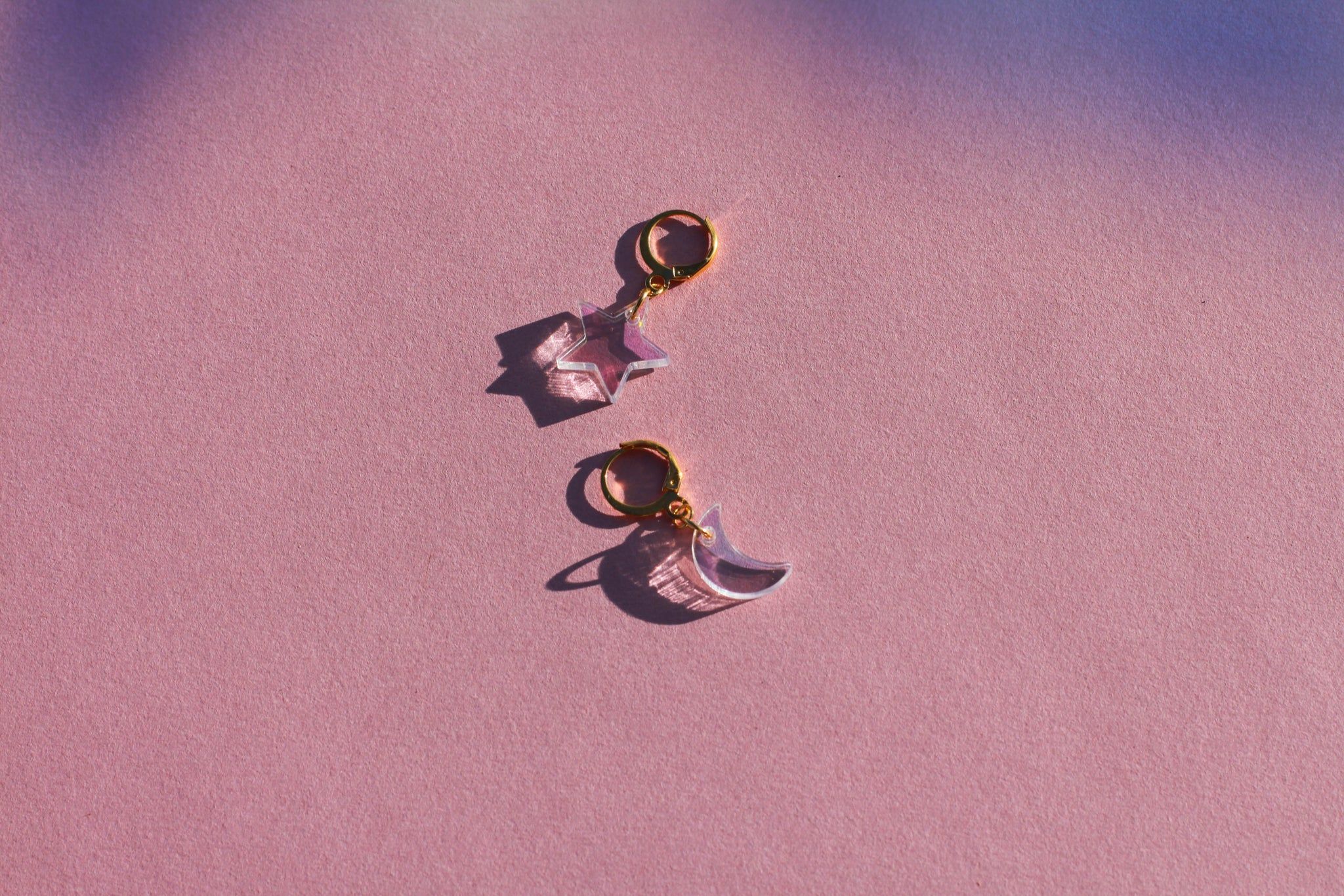 A pair of earrings with a star and moon - Iridescent