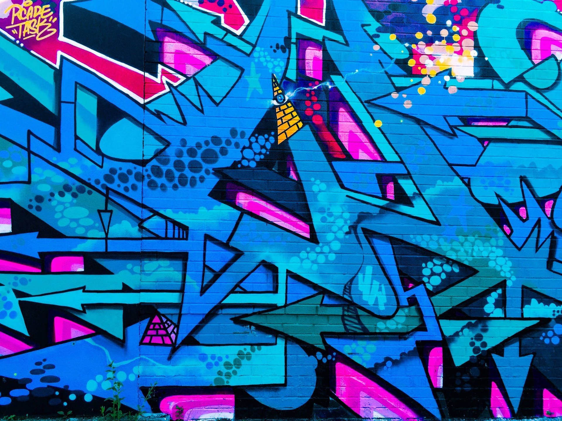A blue brick wall covered in graffiti. - Graffiti