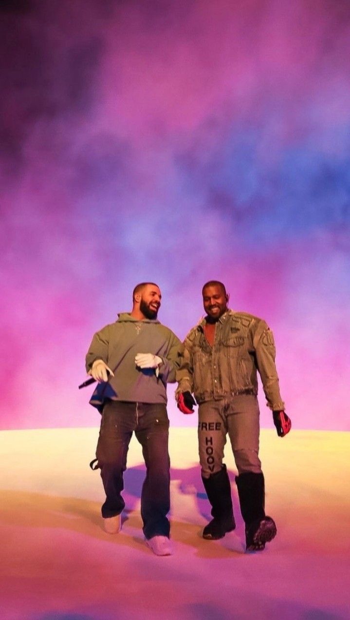 Drake and Kanye West holding hands on a stage - Kanye West