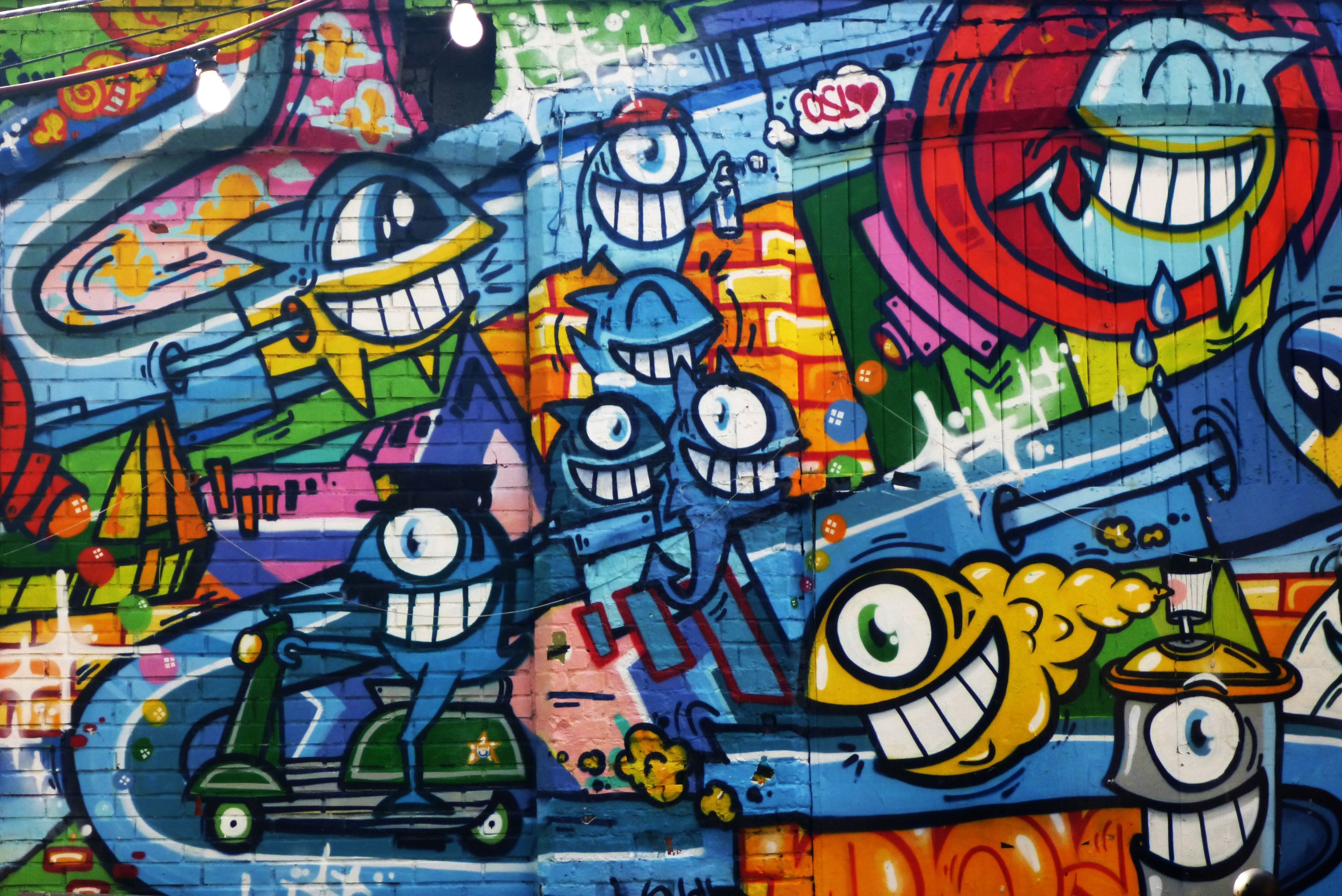 A colorful wall with various graffiti art on it. - Graffiti