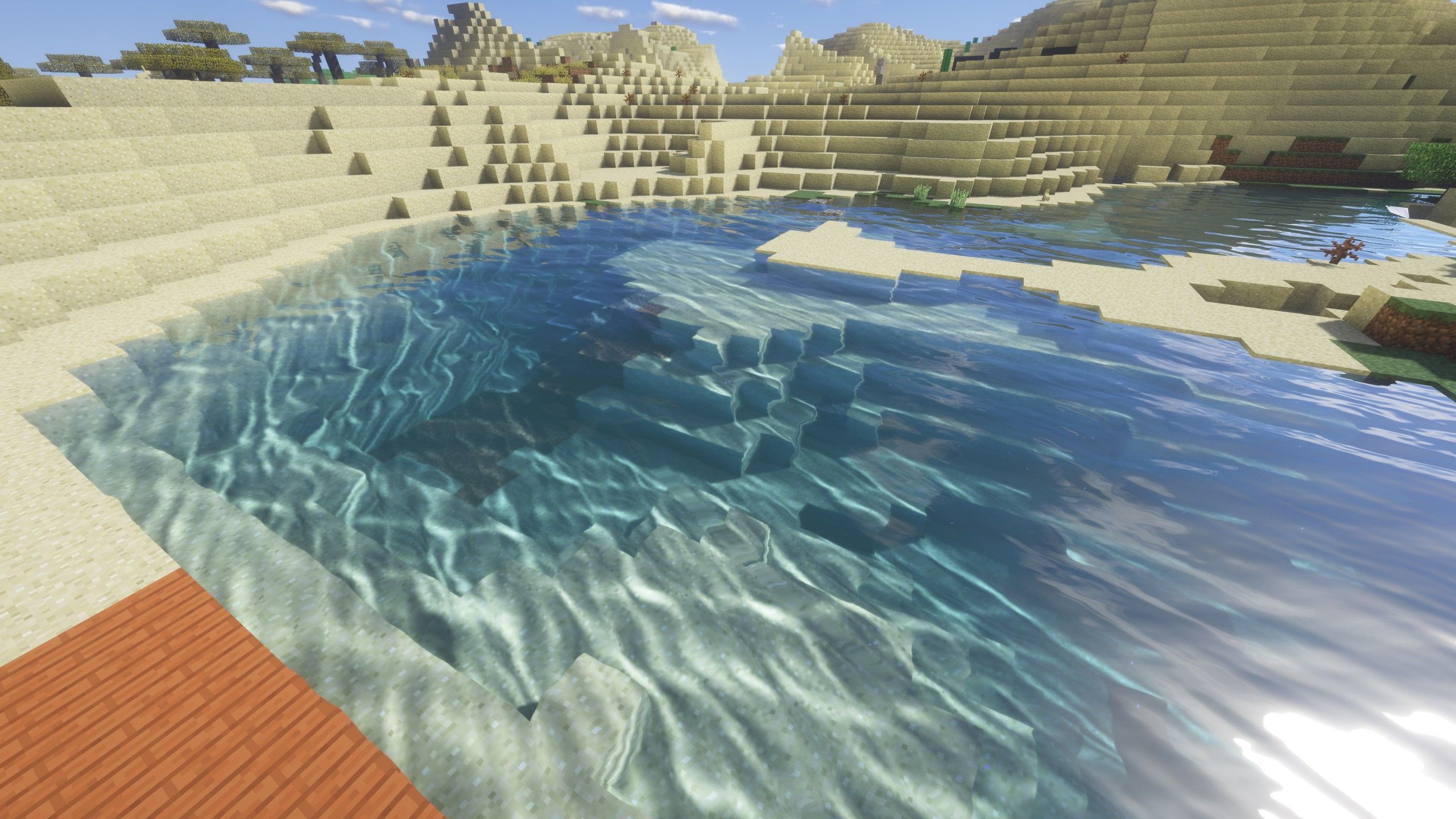A desert oasis with a small pool of water and a sandy hill in the background - Minecraft