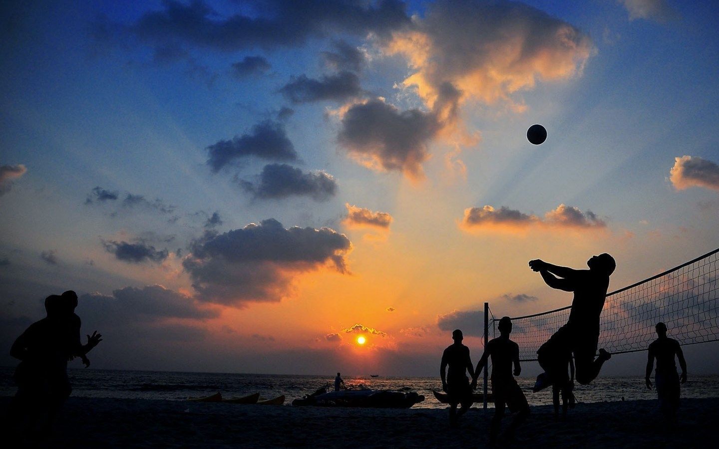People playing volleyball on the beach at sunset - Volleyball