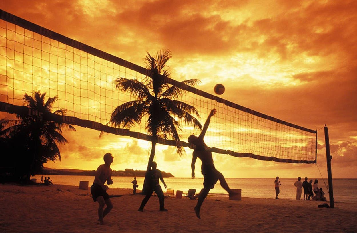 People playing volleyball on the beach at sunset. - Volleyball