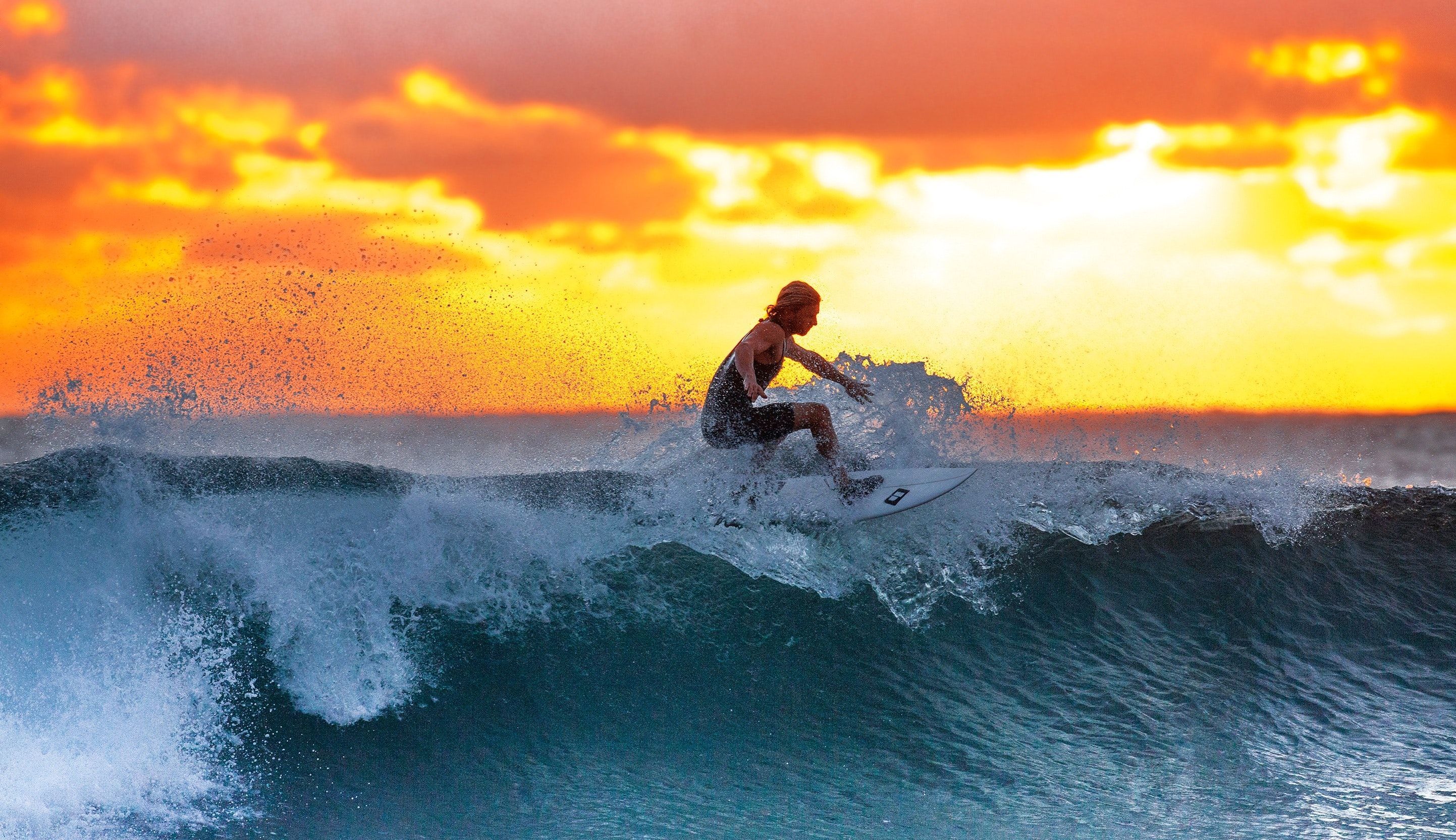 A man riding a wave on top of a surfboard. - Surf