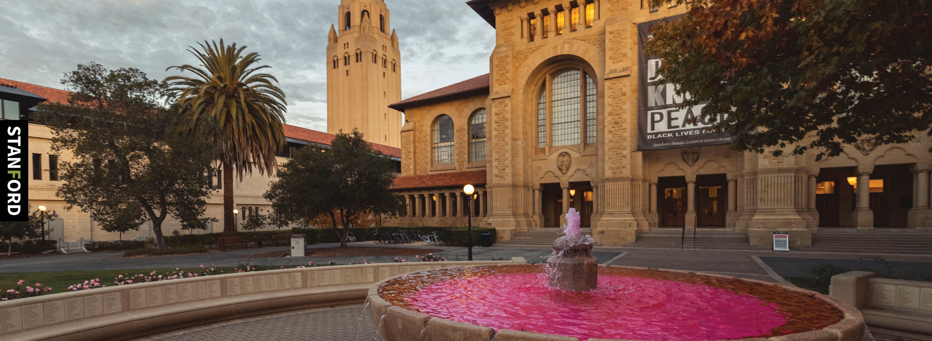 A fountain in front of a building with a clock tower - Stanford