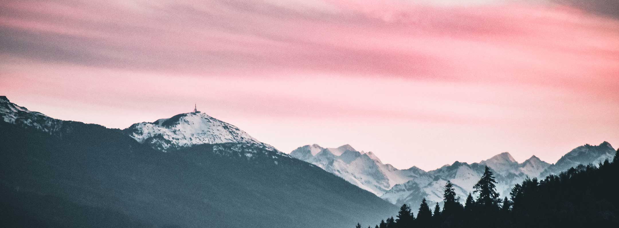 A pink and purple sunset over a mountain range - Mountain
