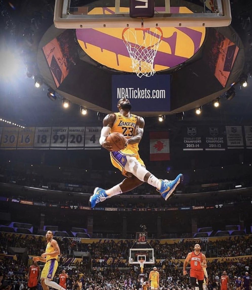 Lebron James jumping up in the air with a basketball in his hand - Lebron James