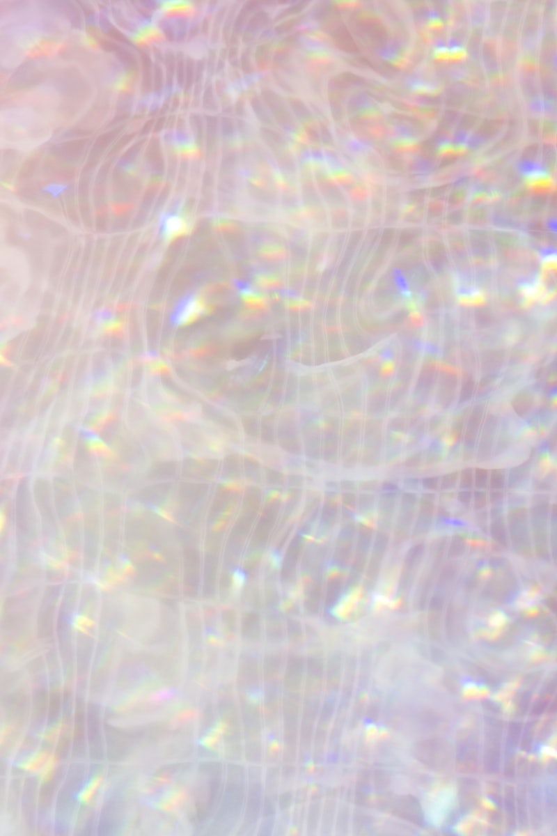 A close up of a pool of water with a rainbow reflection - Holographic