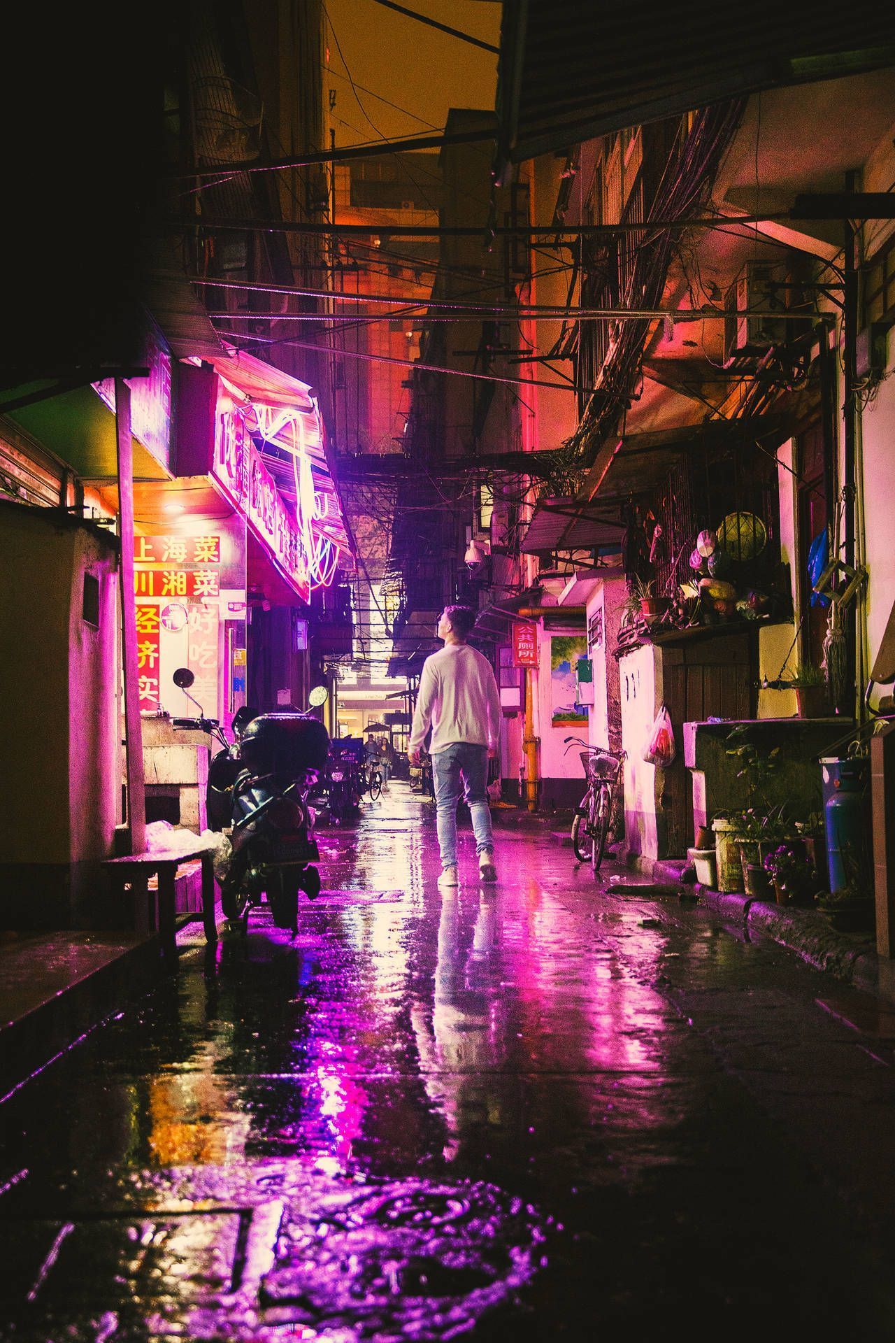A person walking down a street at night with neon lights - Chinese