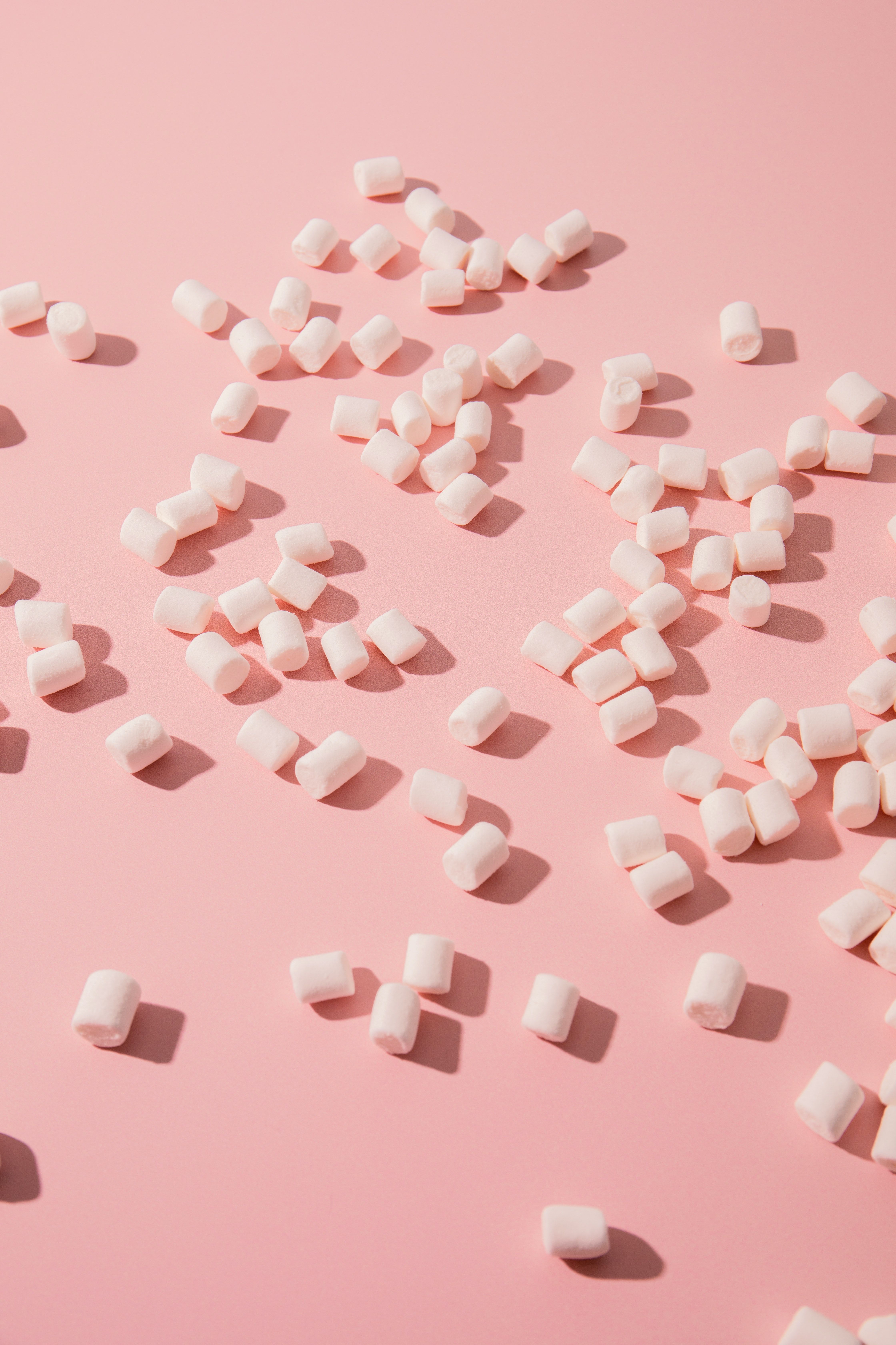 White marshmallows scattered on a pink background - Marshmallows