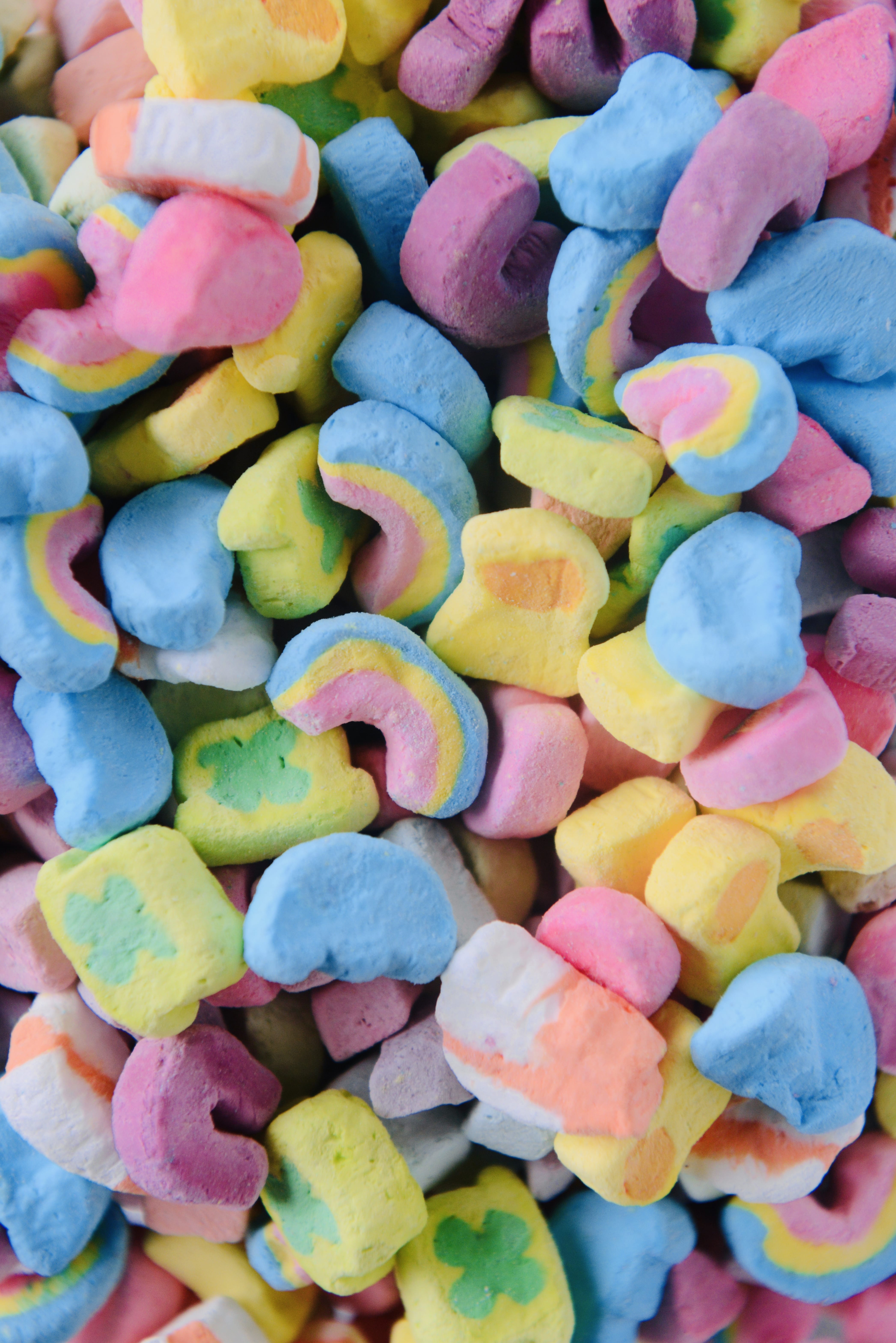 A close up of a pile of colorful cereal marshmallows. - Marshmallows