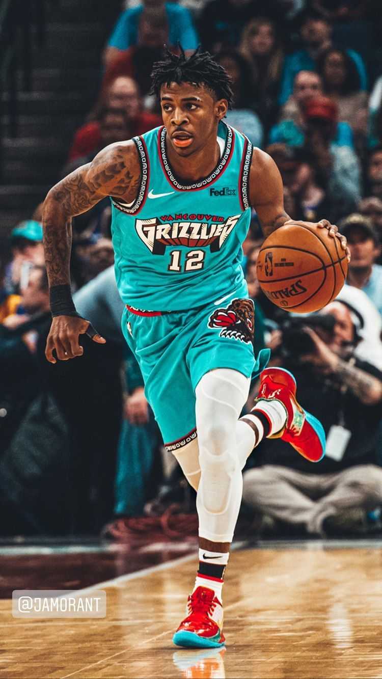 A basketball player in turquoise and red uniform - Ja Morant
