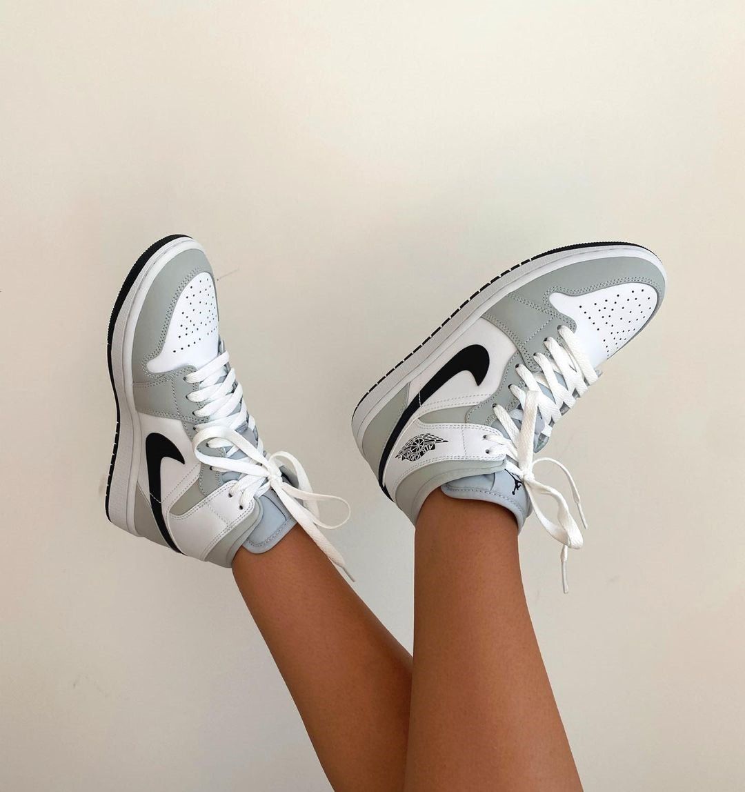 A person wearing white and gray sneakers - Air Jordan 1