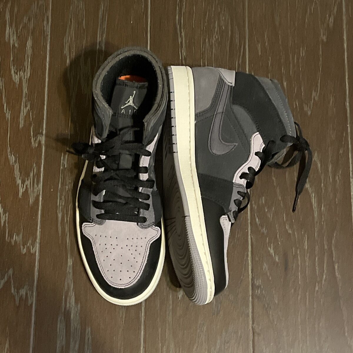 A pair of black and gray sneakers on the floor - Air Jordan 1