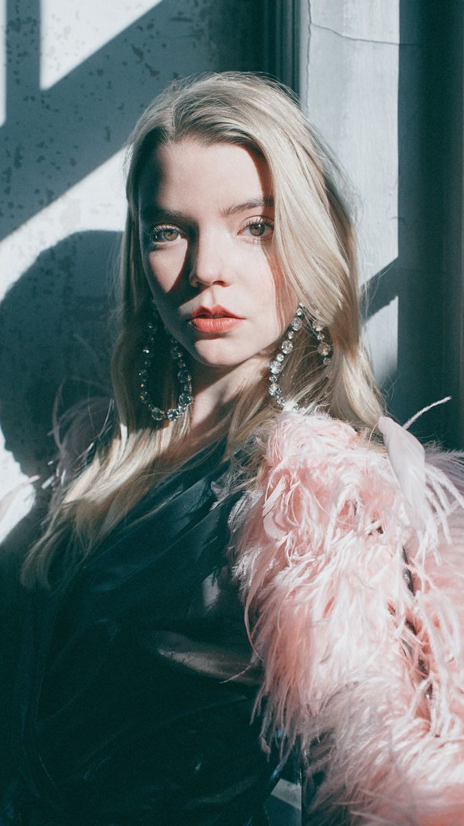 A blonde woman with a pink feathered jacket - Anya Taylor-Joy