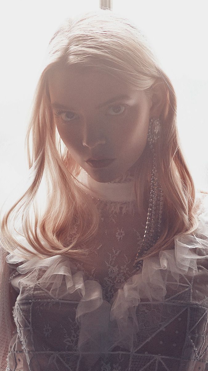 A woman in white dress with earrings - Anya Taylor-Joy