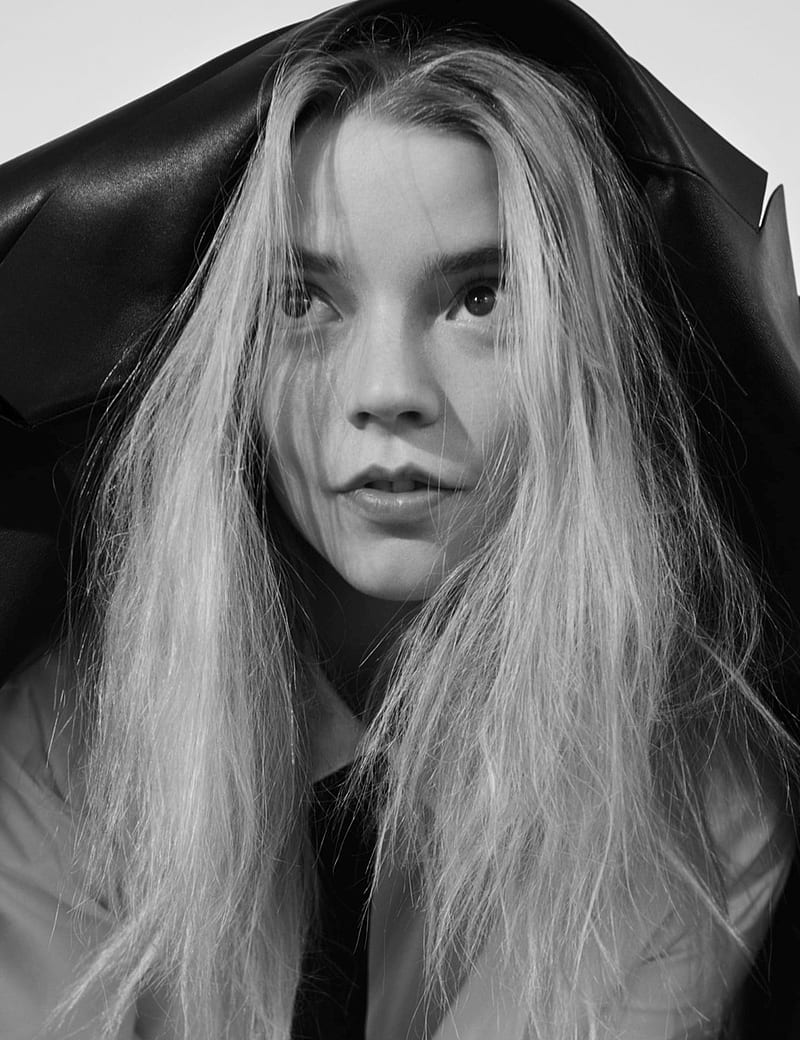 A woman with long hair is standing under an umbrella - Anya Taylor-Joy