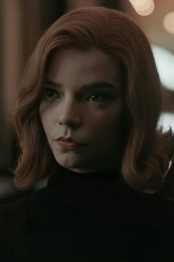 A woman with red hair and black clothes - Anya Taylor-Joy