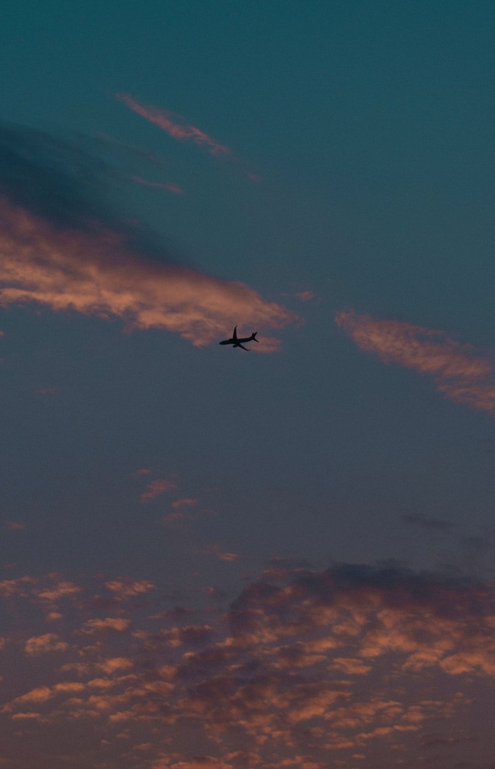 A plane flying in the sky during sunset - Airplane