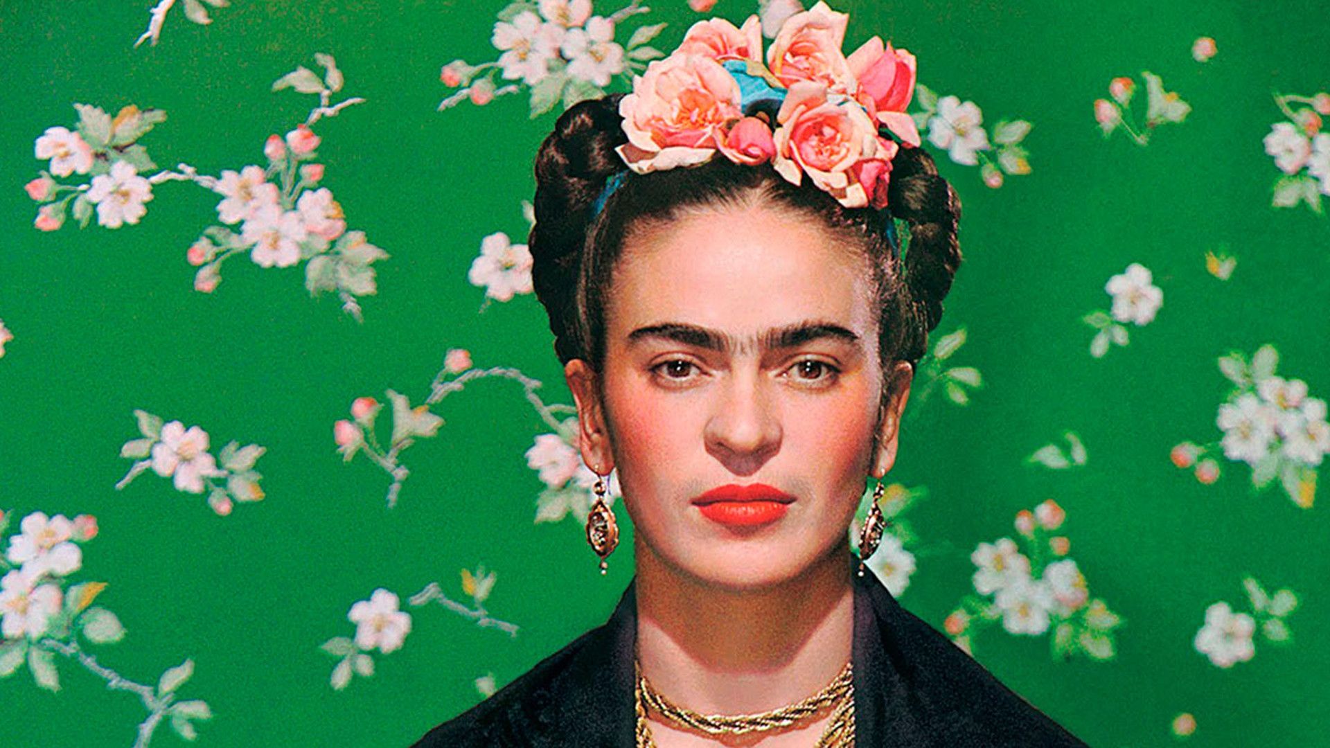 A portrait of Frida Kahlo in front of a green background with flowers. - Frida Kahlo