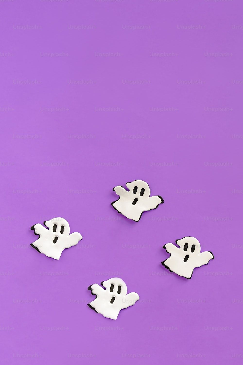 A group of ghost buttons sitting on top of a purple surface photo
