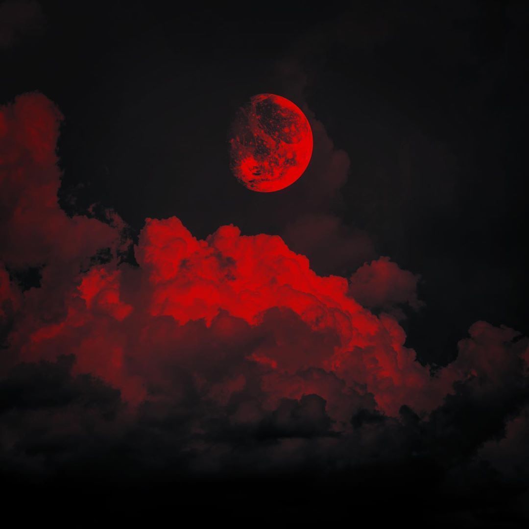 A red moon is seen in the sky with clouds - Crimson