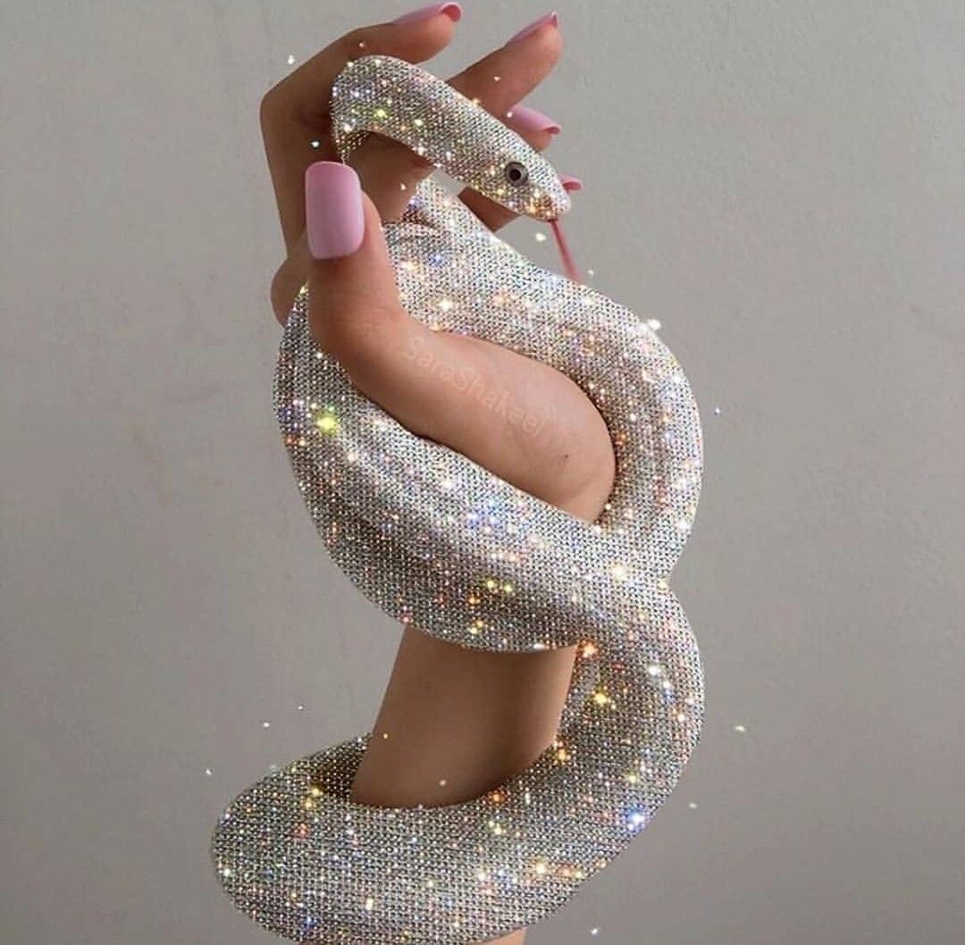 A hand holding a snake made of diamonds - Bling