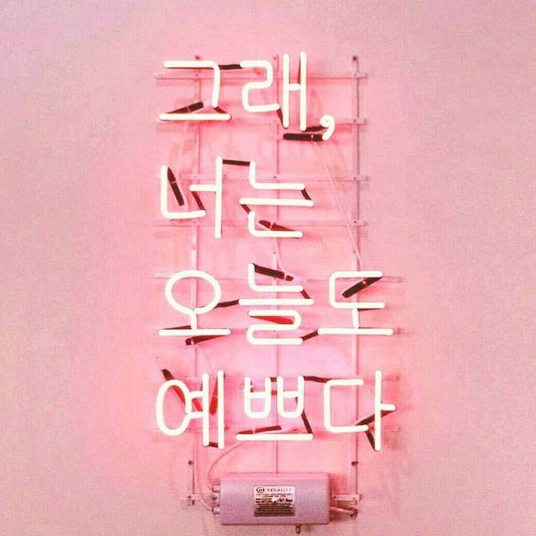 A pink neon sign with Korean characters - Korean