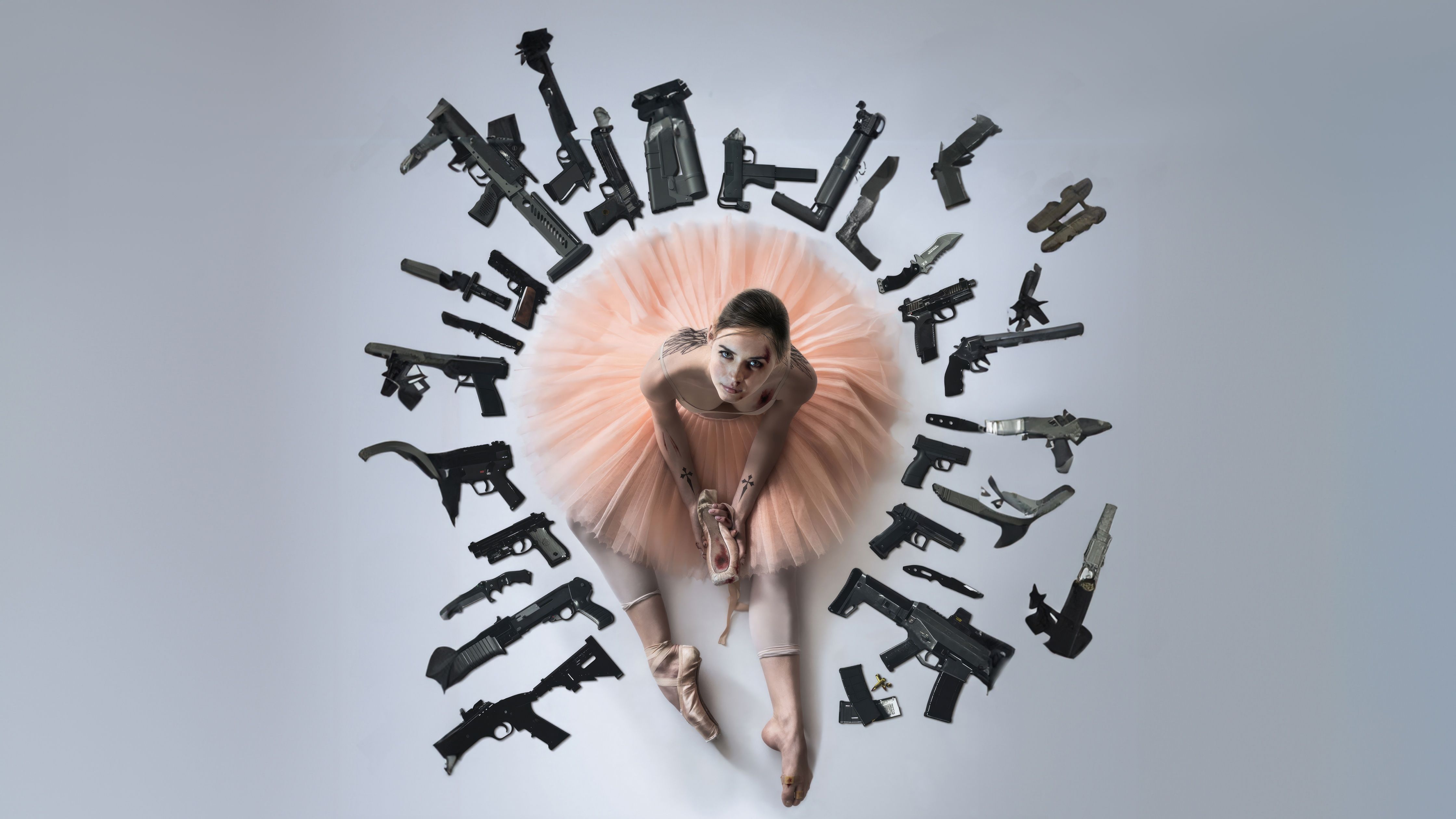 A woman in pink tutu surrounded by guns - Ballet