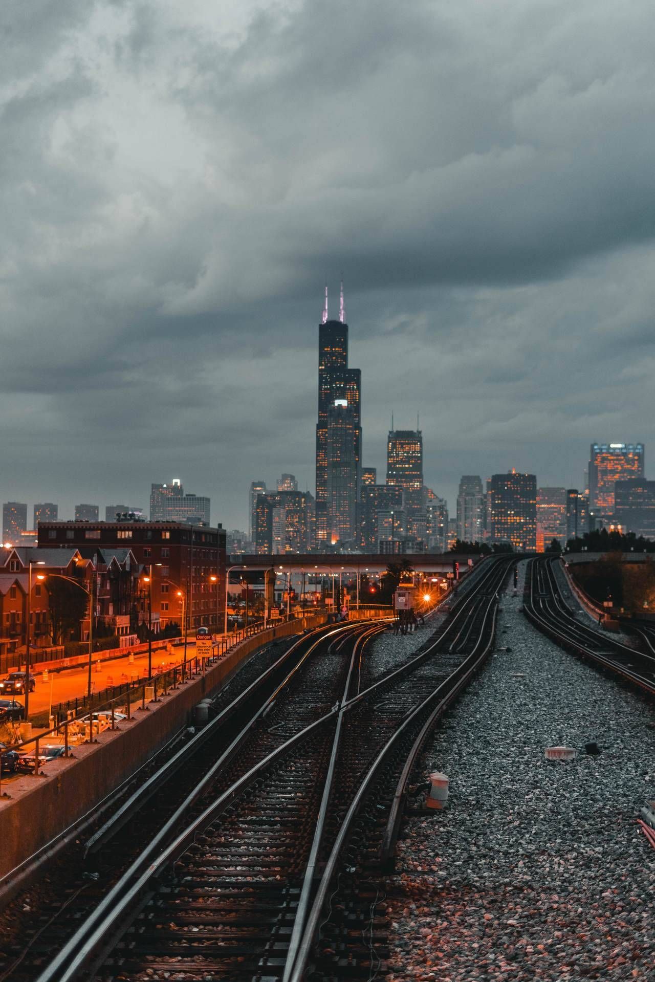 The Chicago skyline at dusk with train tracks in the foreground. - Chicago