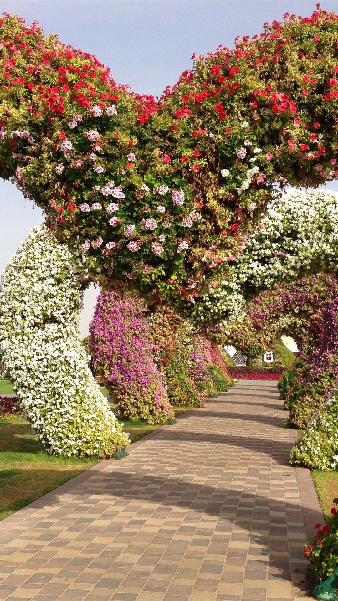 A pathway with flowers and trees - Garden