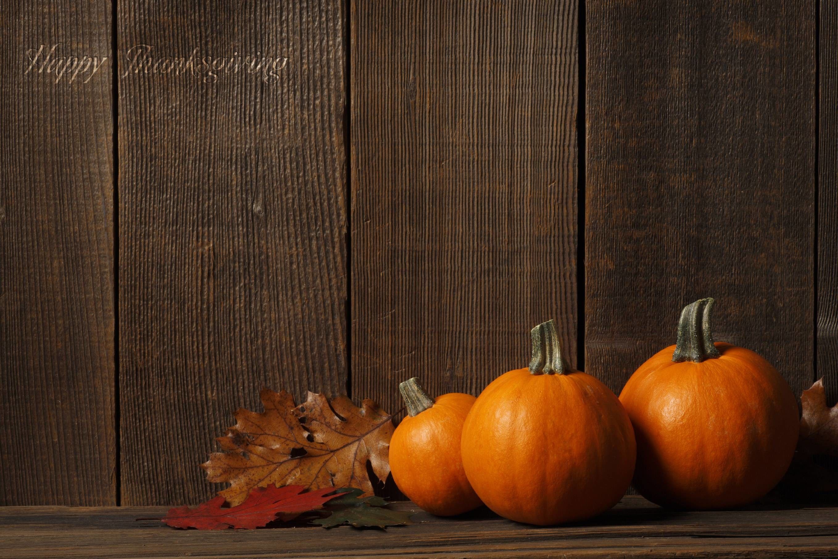 A few pumpkins and leaves on a wooden table. - Thanksgiving
