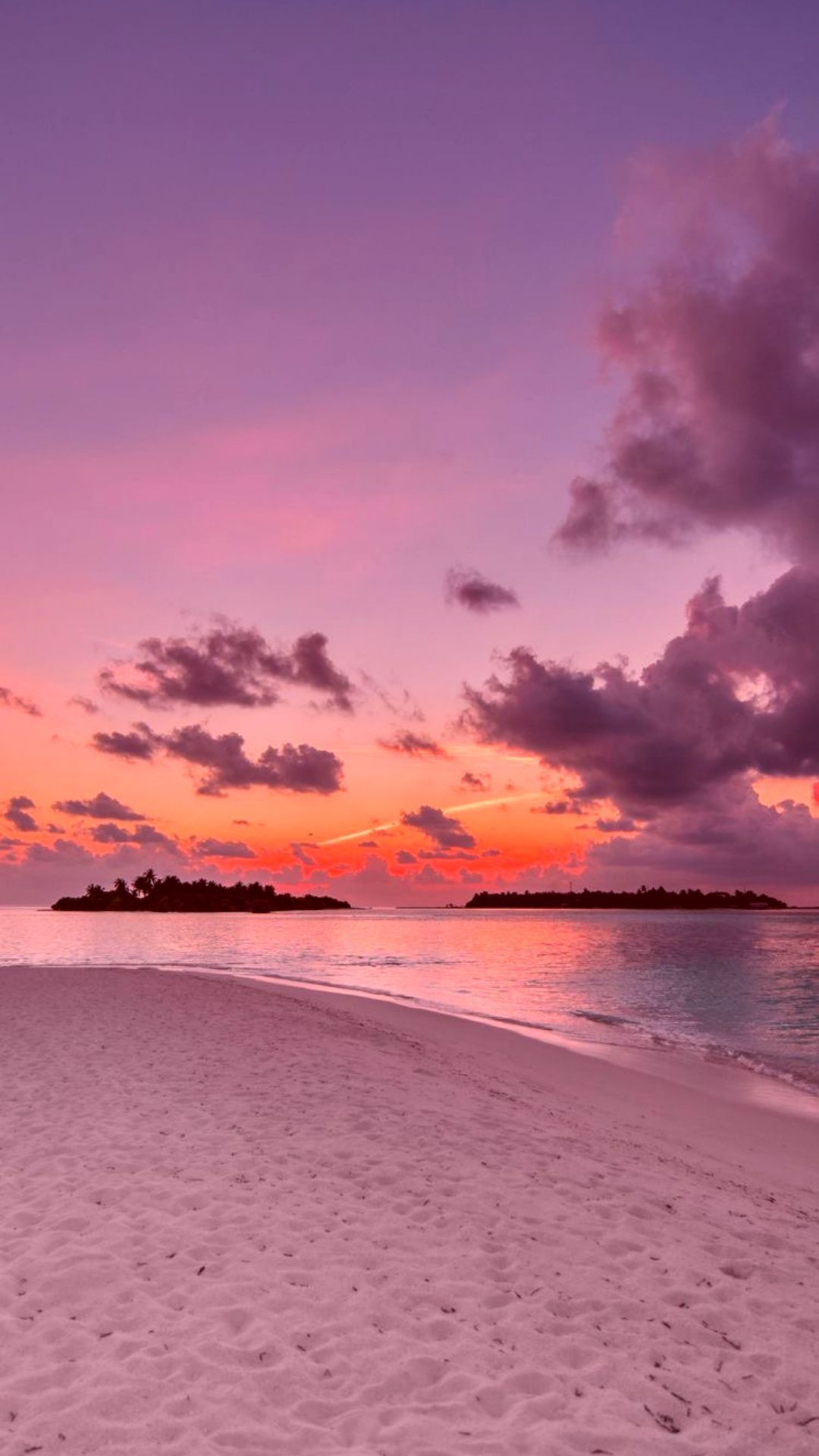 A beach with sand and water at sunset - Bright