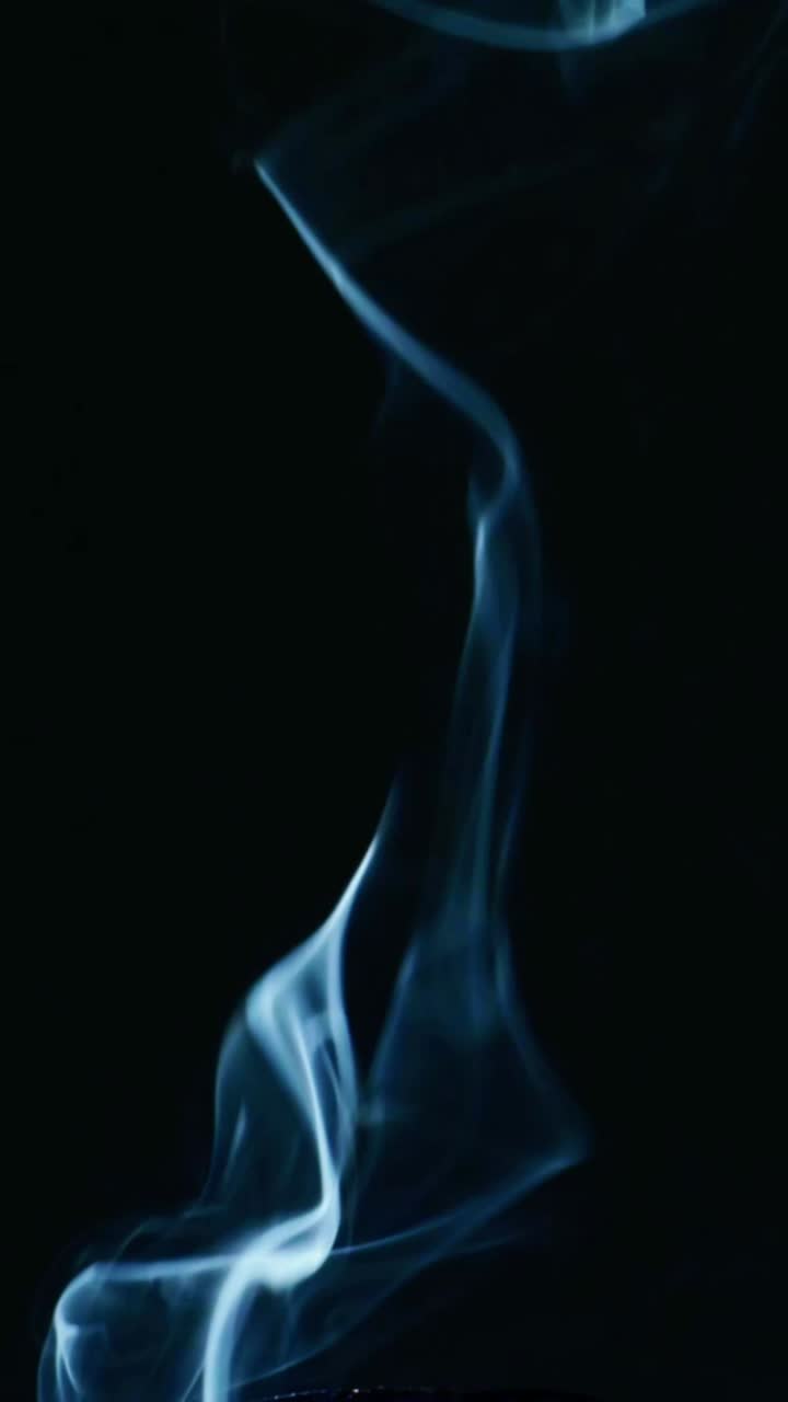 Premium stock video of cigarette is rising against black background, mystic atmosphere with porch smoke swirls