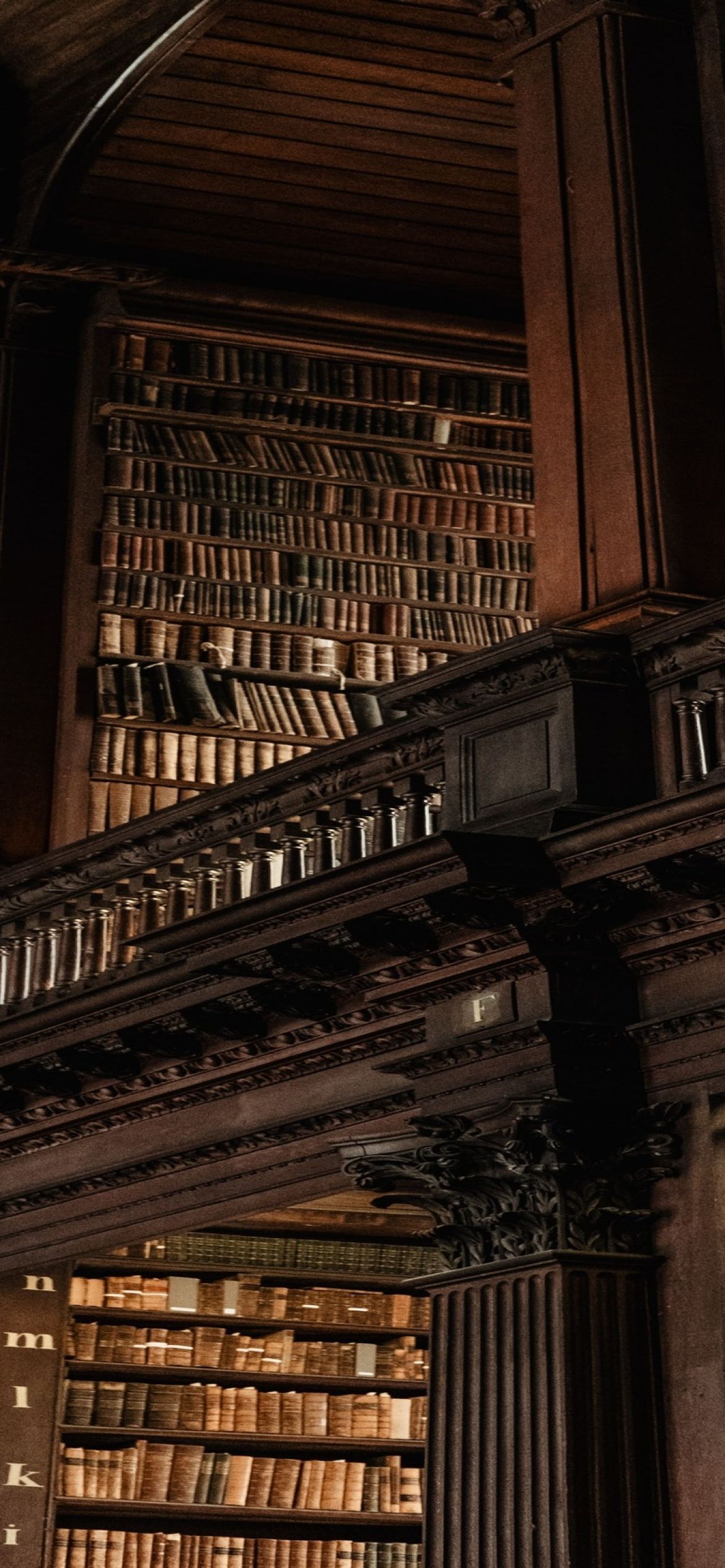 A bookshelf with many books in a room. - Library