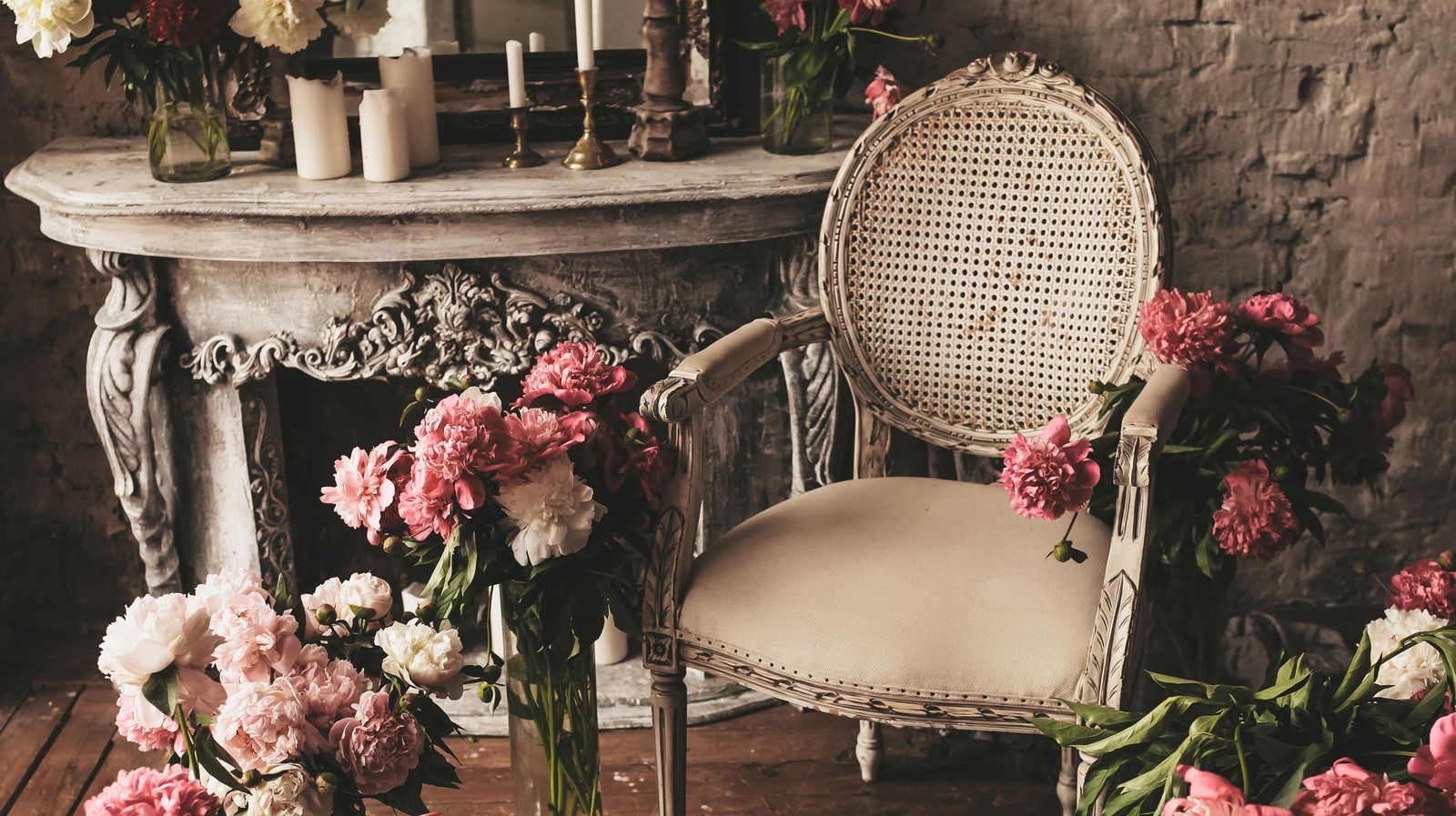 A vintage chair with a pink cushion sits in front of a fireplace. - Victorian