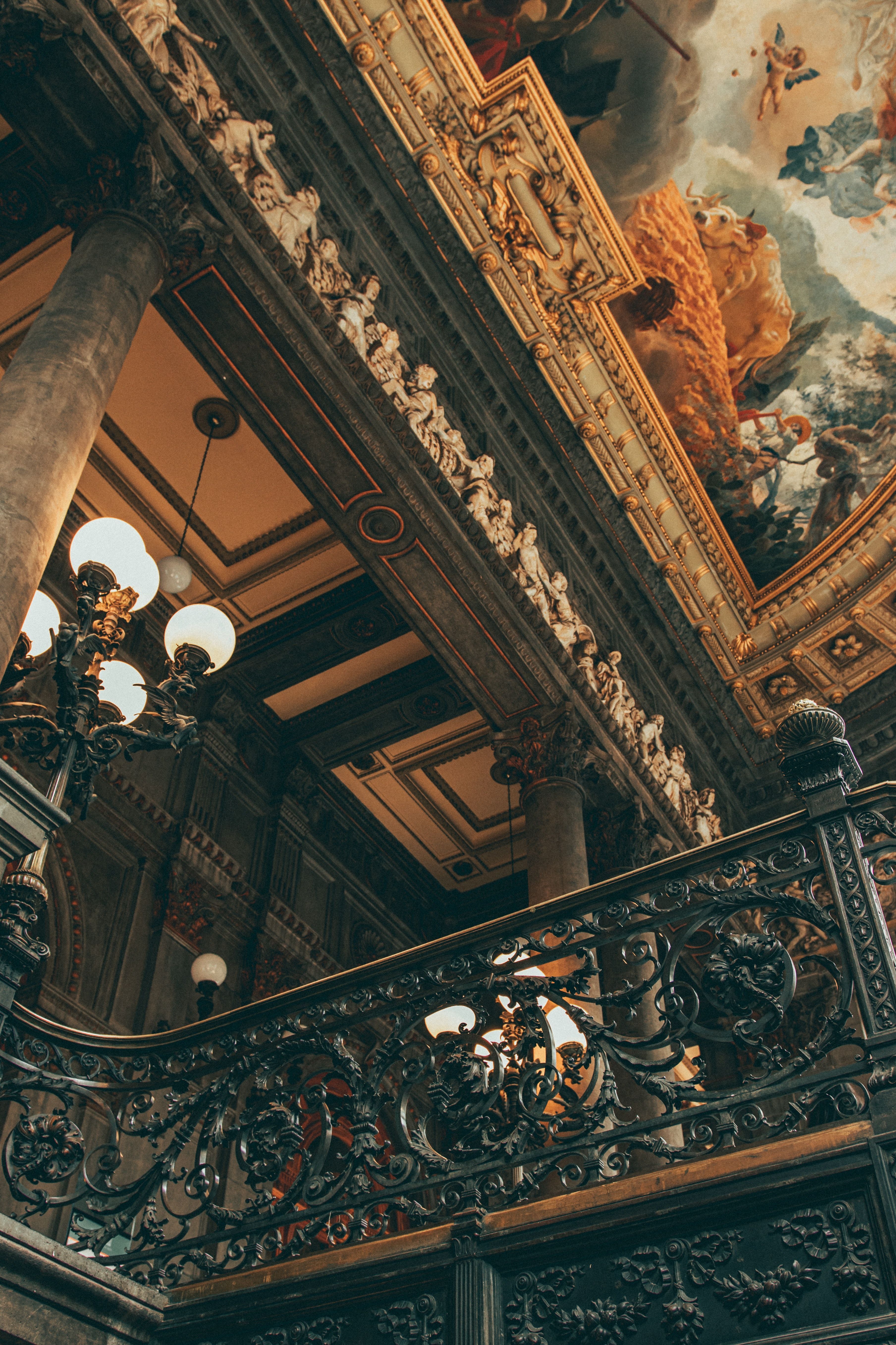 A staircase with ornate railings and lighting - Victorian