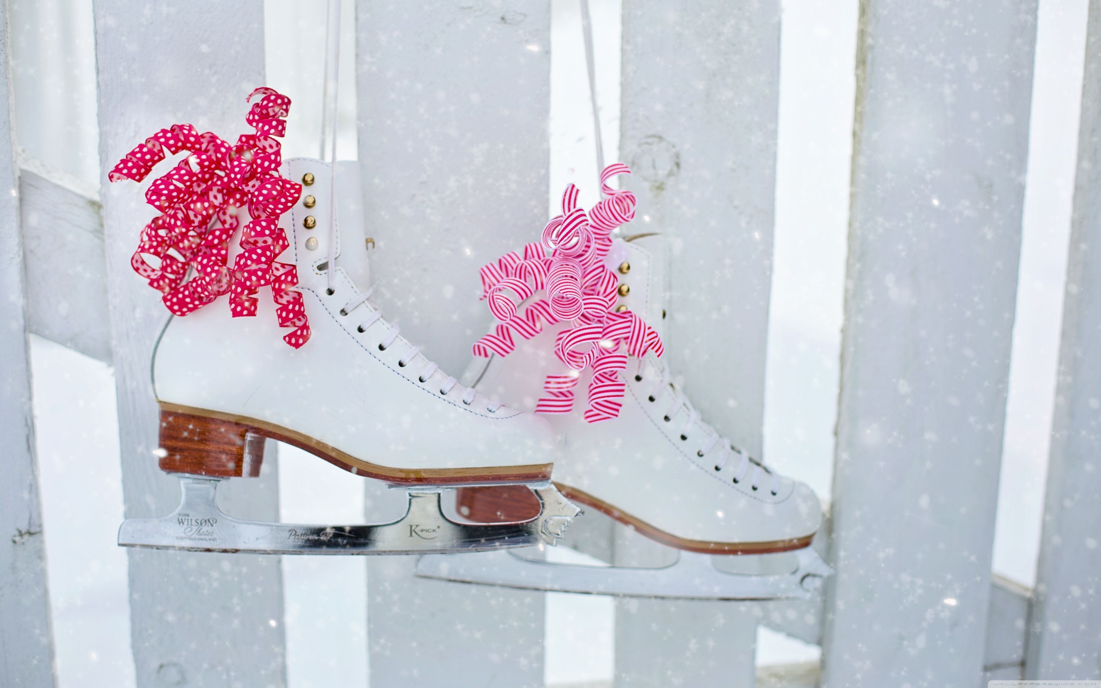 A pair of white skates with pink bows on them. - Skate