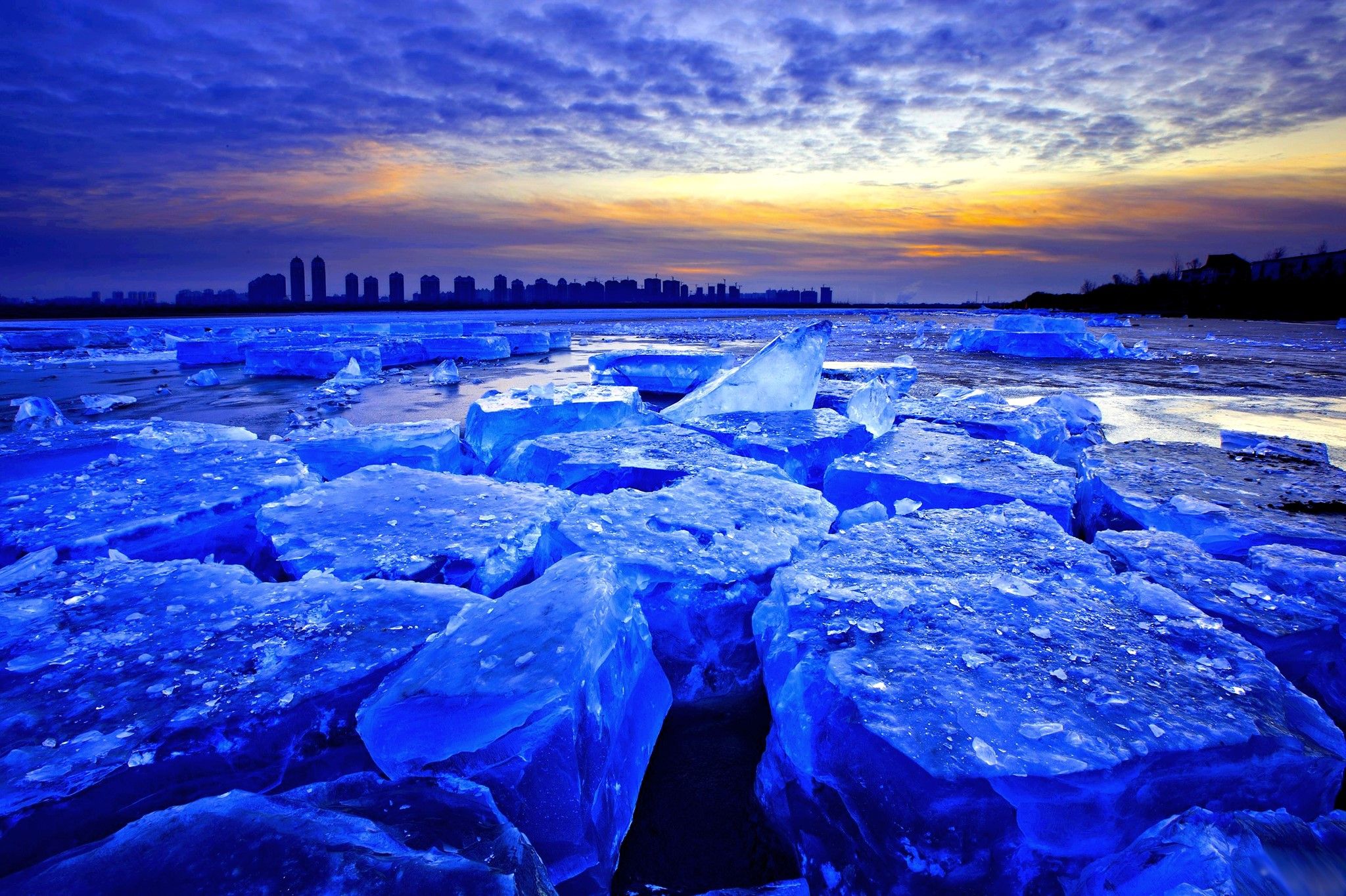 Blue ice in the foreground with a city skyline in the distance - Ice