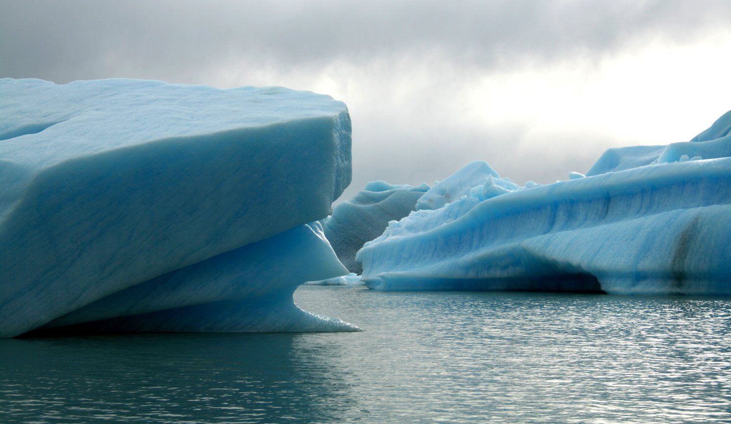 Icebergs in the ocean with a cloudy sky - Ice