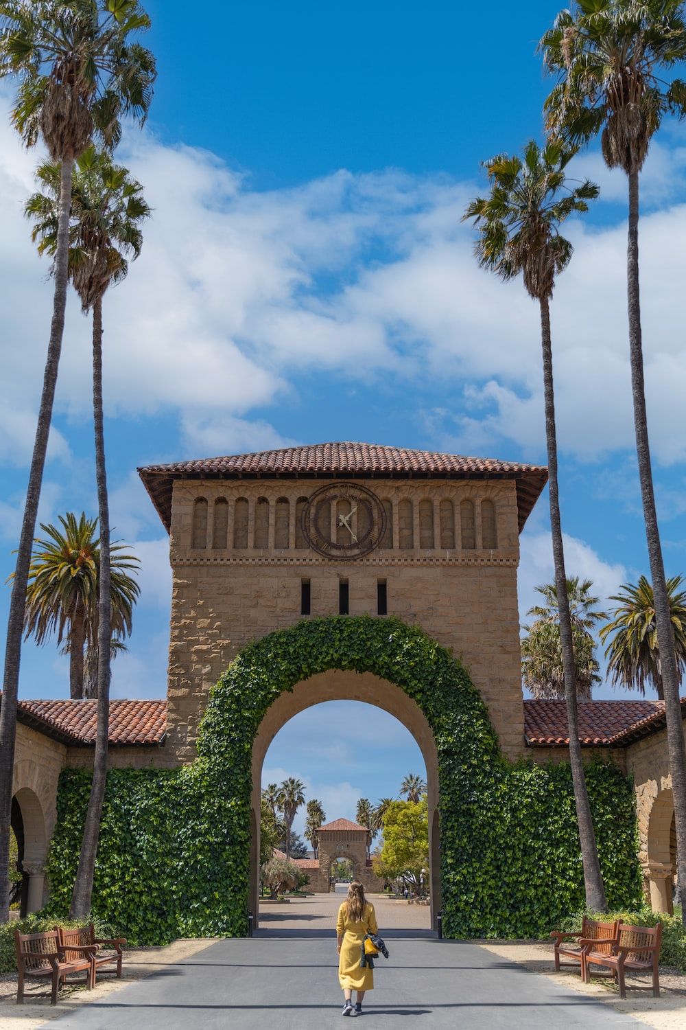 A man riding his bike in front of an archway - Stanford