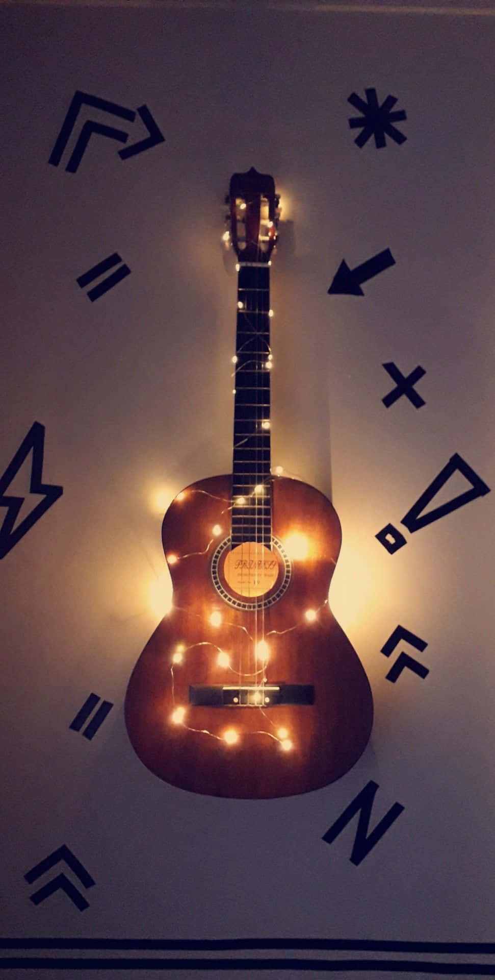 A guitar with lights on it hanging from the  - Guitar