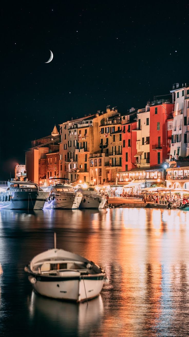 A boat is in the water at night - Italy