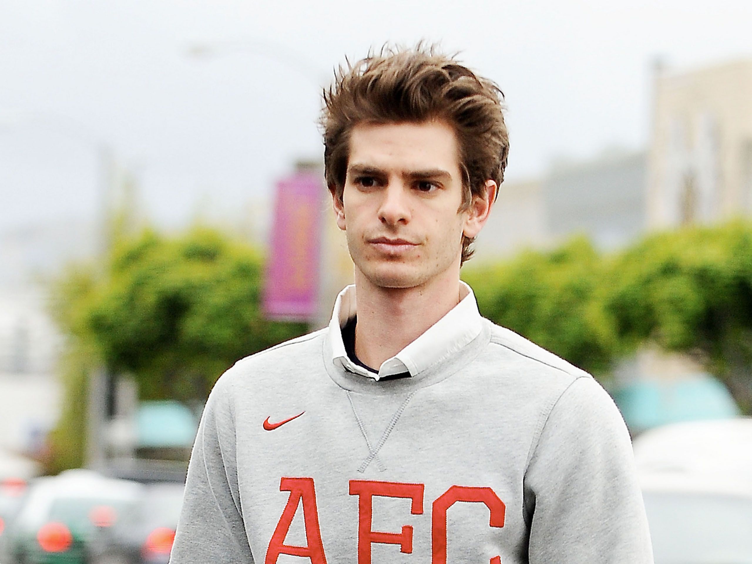 Andrew Garfield wears a grey Nike sweater with red letters on it - Andrew Garfield