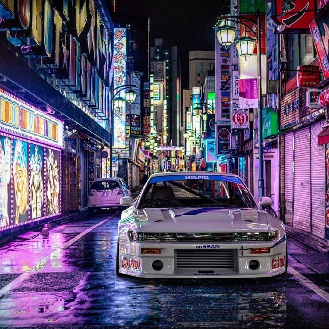 A car in the middle of an alleyway at night - JDM