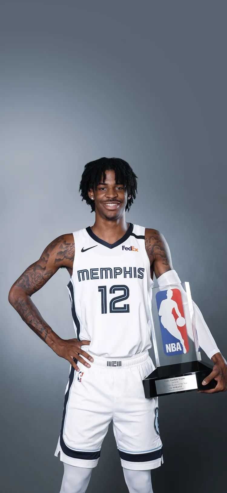 Ja Morant of the Memphis Grizzlies holds the 2020-21 NBA Rookie of the Year trophy. - Ja Morant