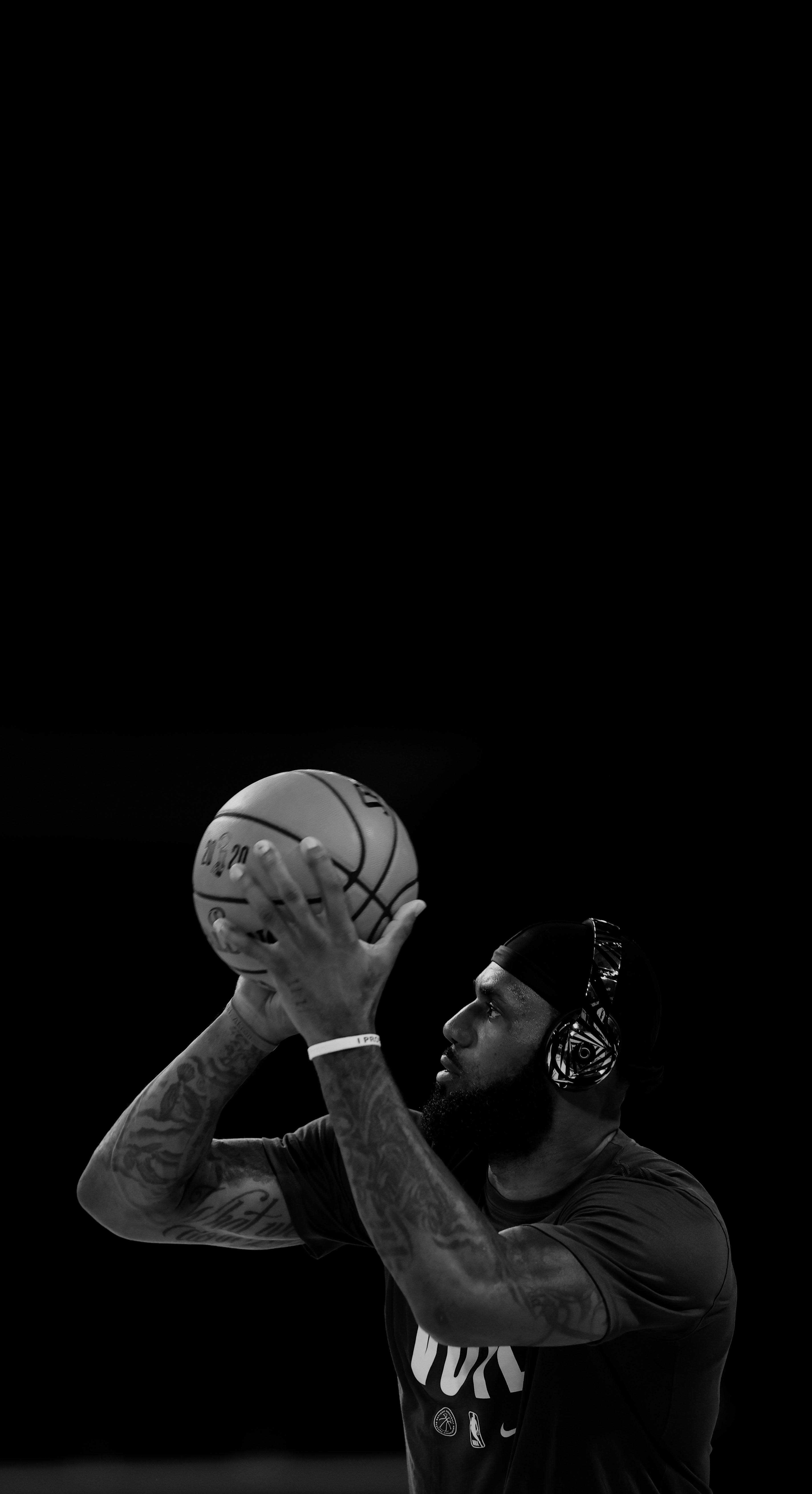 Black and white photo of Lebron James holding a basketball up to his face. - Lebron James