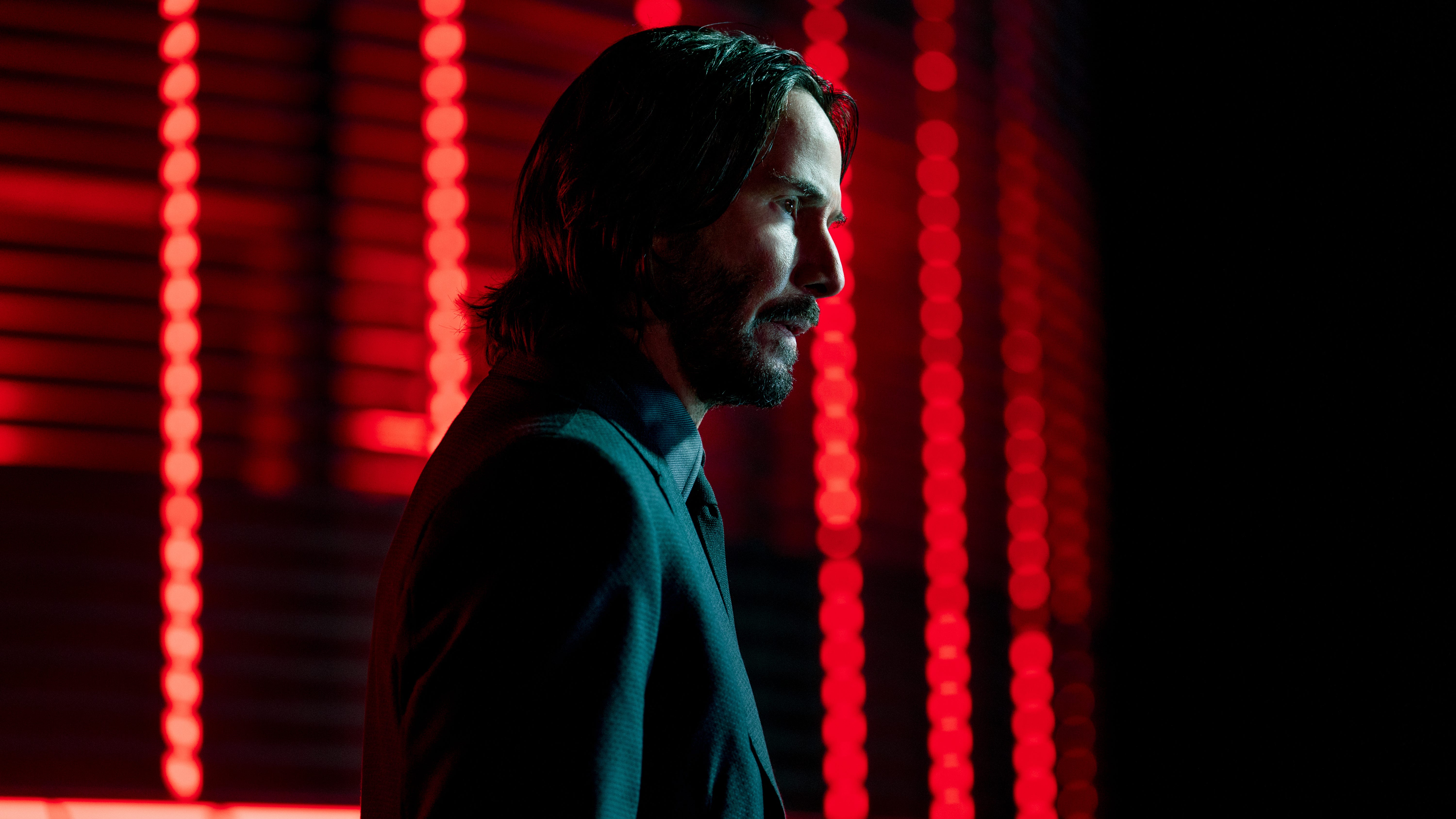 John Wick (Keanu Reeves) in a red-lit room - John Wick