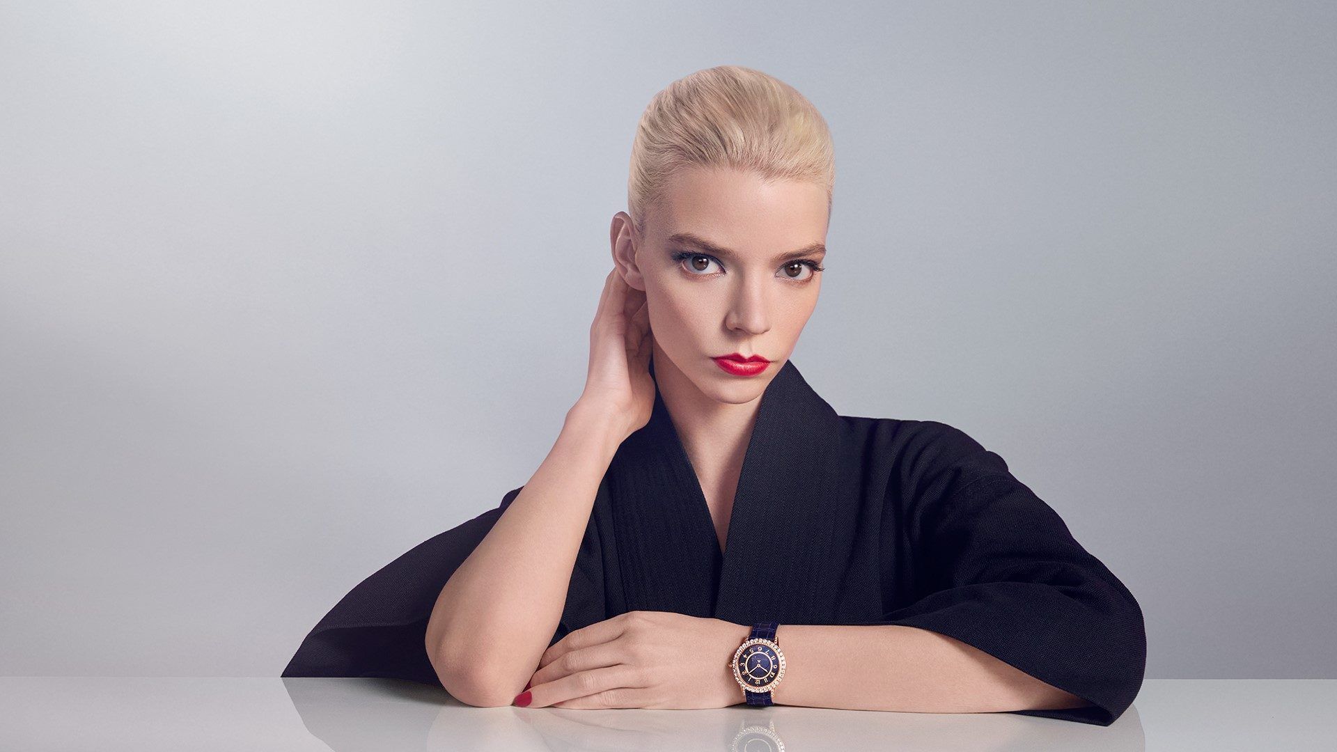 A woman in a black top with a watch on her wrist - Anya Taylor-Joy