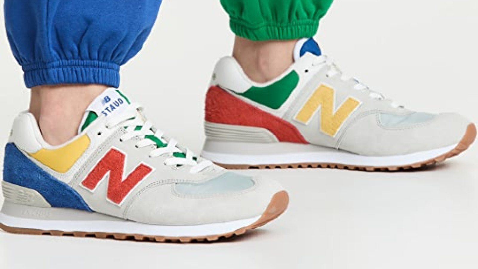 A person wearing a white sneaker with a colorful sole - New Balance